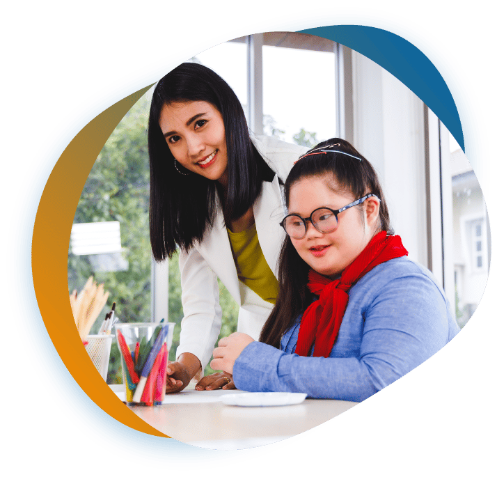 A teacher supporting a student at a classroom desk