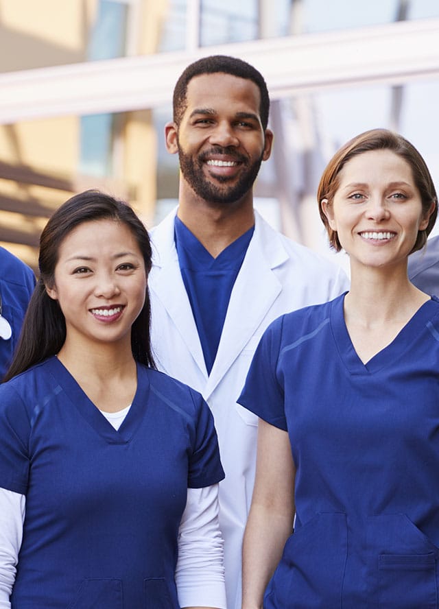 Three healthcare professionals standing together