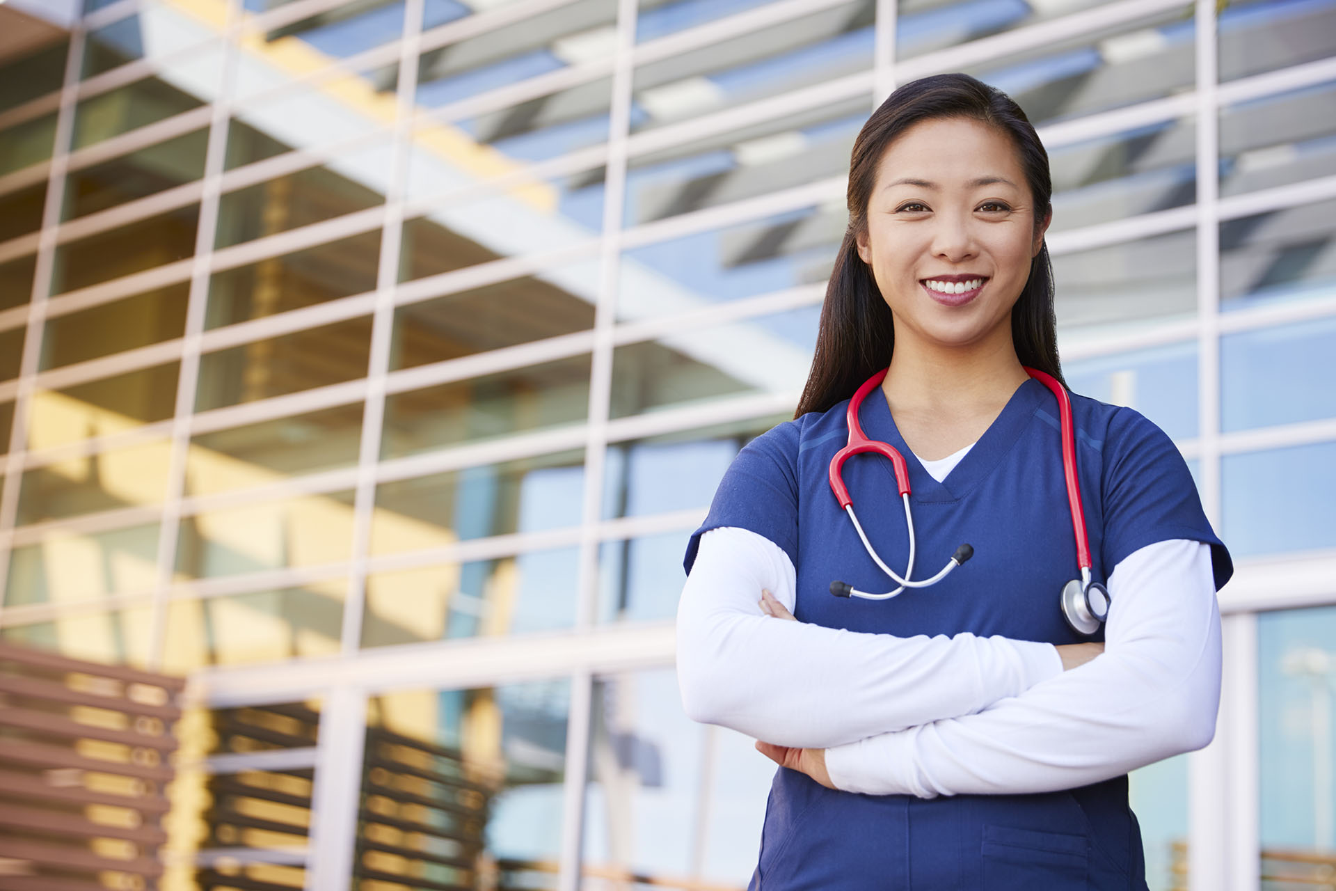 International healthcare provider standing outside a hospital